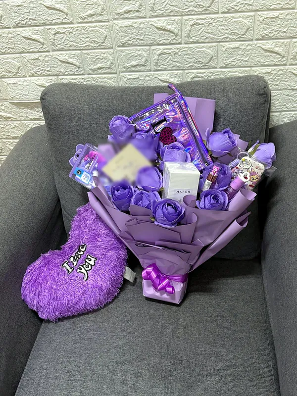 Lilac gift bouquet with roses and little treats
